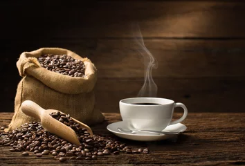 Papier Peint photo autocollant Café Tasse de café avec de la fumée et des grains de café sur fond de bois ancien