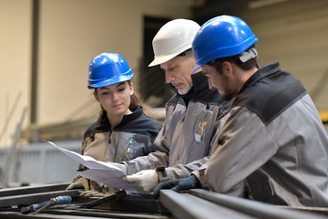 Apprentice working in steelworks plant, with instructor