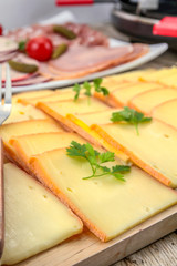 Fototapeta na wymiar fromage à raclette et charcuterie sur une table