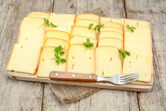 tranches de fromage &agrave; raclette sur une planche &agrave; d&eacute;couper