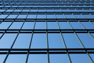 Metal grid in perspective against a blue clear sky