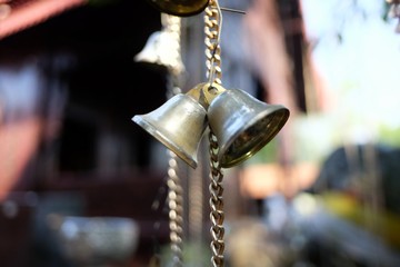 A group of small  bronze bells hanging from a chain in the Buddha temple area