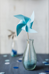 Windrad in Blau auf Holz in Vase aus Glas mit Konfetti - Zukunft, Wind, Freiheit, Nachhaltigkeit -...