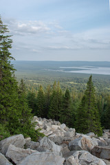 view of the lake from the mountain in the spruce forest with white rocks