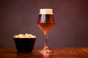 Glass of light beer with chips snack on the counter table in bar. Alcohol drink. Food photography concept, copy space.