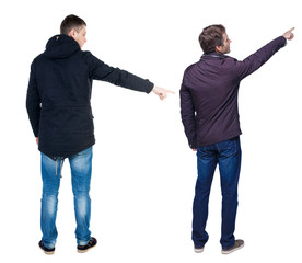 Back view of couple couple in winter jackets pointing.