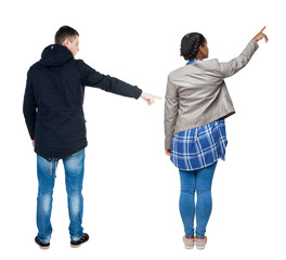 Back view of couple couple in winter jackets pointing.
