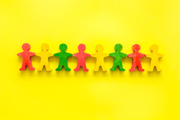 Team work, teambuilding concept. People cutouts on yellow background top-down copy space