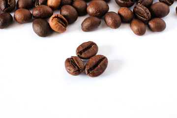 Coffee beans lie on a white sheet of paper