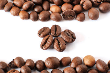 Coffee beans lie on a white sheet of paper