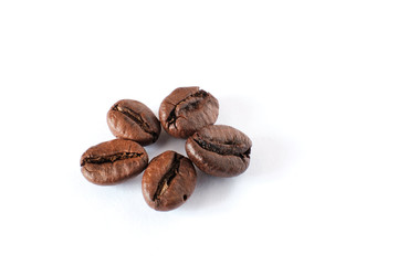 Coffee beans lie on a white sheet of paper