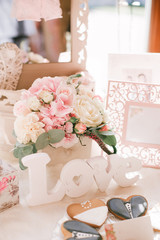 Beautiful floral arrangement of roses and pink hydrangea and the word love in the decor