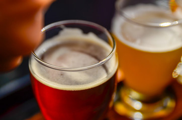 Craft beer tasting: an amber beer glass, next to a glass of blonde beer