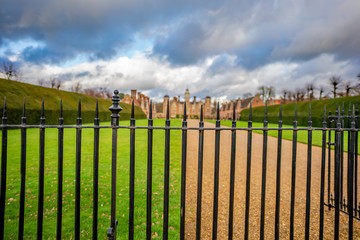  Selective focus on a black metal fence and gate on the border of a stately home out of focus in...
