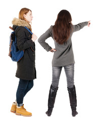 Back view of two pointing young girl in winter jacket.