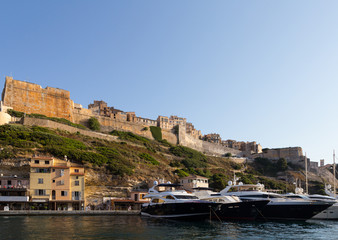 Fototapeta na wymiar Luxury yachts anchored in front of the famous Bonifacio citadel in Corsica in France on a sunny summer day.