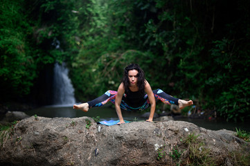 Yoga practice and meditation in nature. Woman practicing near river