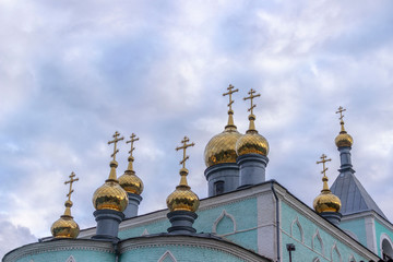 Fototapeta na wymiar Golden domes of a Christian Church on a cloudy day