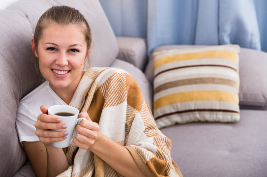 Girl is resting with tea in plaide