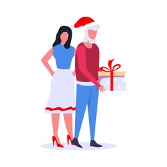 A man in a burgundy sweater and blue jeans and a Santa Claus hat with a woman in red shoes comes with a gift for the holiday