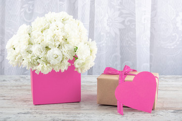 Bouquet of white roses in a pink box and a symbol of the heart for the inscription. Valentine's day, wedding, declaration of love. Space for text, front view, copy space.