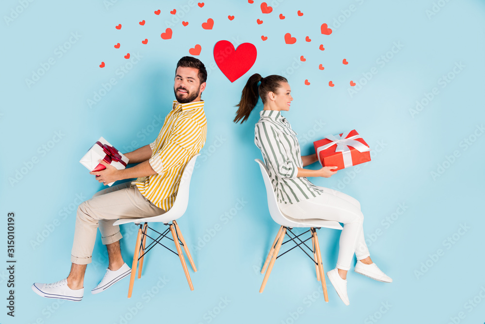 Sticker Top view above high angle flat lay flatlay lie concept view of his he her she nice cheerful couple sitting holding in hands gifts isolated on bright vivid shine vibrant blue turquoise color background