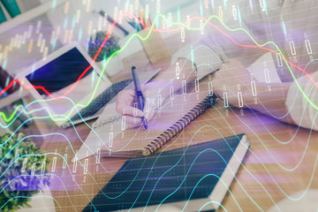 Financial graph displayed on woman's hand taking notes background. Concept of research. Double exposure