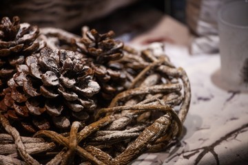 Fototapeta premium three pinecones nestled in wooden handmade wreath covered in fake snow