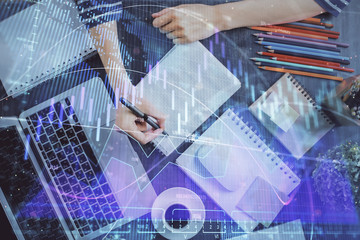 Financial chart drawn over hands taking notes background. Concept of research. Double exposure