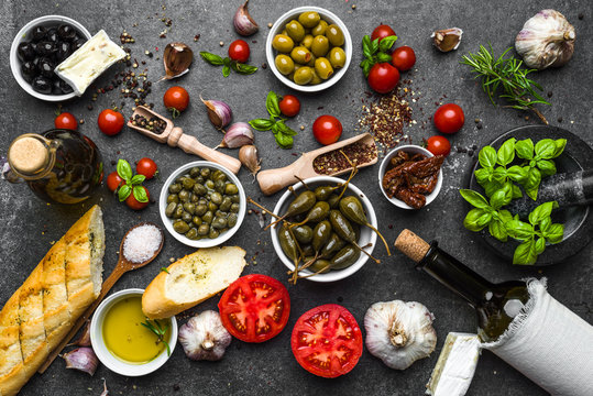 Mediterranean food background with herbs, olive, oil, tomatoes, basil