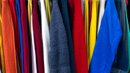 sweaters of different colors hanging