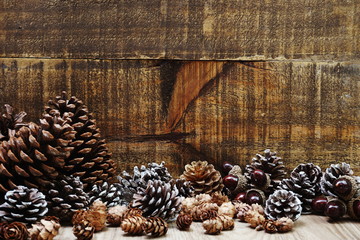 Holiday decoration with Rustic wooden background with pine cones