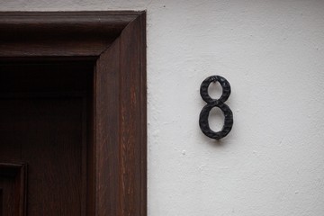 vintage number 8 on white wall with door frame
