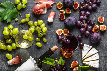 Buffet with wine snack set or french appetizer. Glass and bottle of red wine, cheese, meat and fruit.