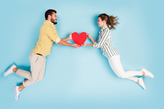 Top view above high angle flat lay flatlay lie concept full length body size view of attractive cheerful couple holding heart isolated on bright vivid shine vibrant blue turquoise color background