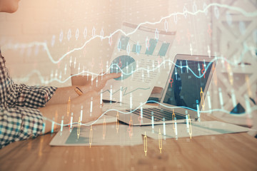 Double exposure of financial graph with man works in office on background. Concept of analysis.