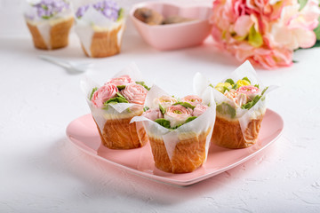 Flower cupcakes on white background. Beautiful sponge cup cakes decorated with buttercream roses.