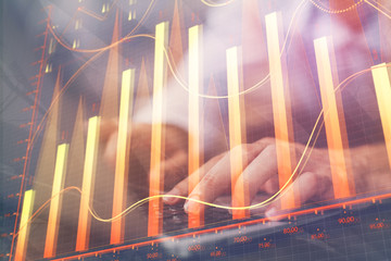 Forex graph with businessman working on computer in office on background. Concept of hardworking. Multi exposure.