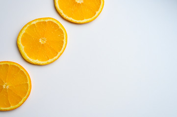 fruit pattern of three fresh orange slices arranged diagonally on the side on a white background. space for text