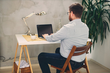 Young male architect sitting at his desk in modern office.