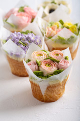 Flower cupcakes on white background. Beautiful sponge cup cakes decorated with buttercream roses.