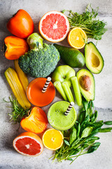 Green and orange detox smoothie in glass. Ingredients for detox smoothie background. Healthy food concept.