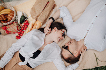 Young Happy Couple Dressed Alike in White T-shirt Having Fun on Picnic, Weekend Outside the City, Holidays Concept