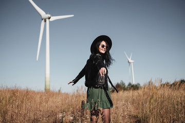 Happy Traveling Girl Enjoying a Trip on the Field Road with Electric Wind Turbine Power Generator...