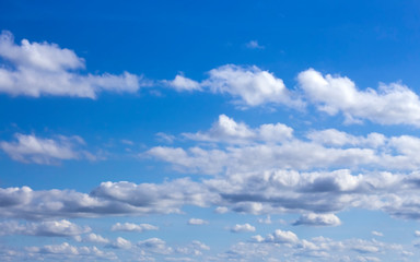 Naklejka na ściany i meble floating clouds in the sunlit blue sky