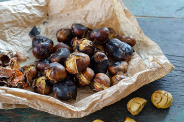 Grilled chestnuts on the wooden table.