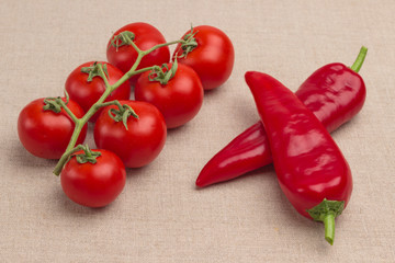 Vegan food concept. Set of products for vegetarian nutrition. Tomatoes on a branch and chili peppers on burlap.