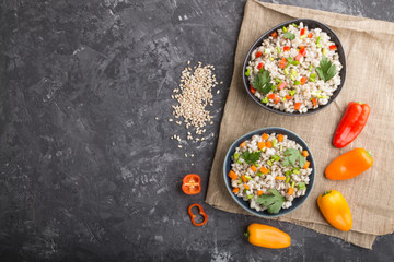 Pearl barley porridge with vegetables in blue ceramic bowls.  Top view, copy space.