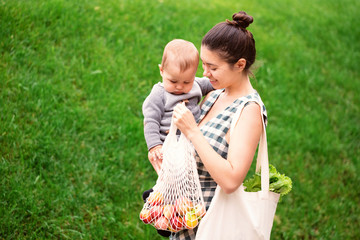 Young woman holding textile glocery eco bag with fruits and vegetables