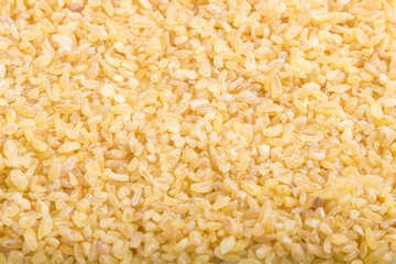 Texture of raw bulgur. Side view, close up, macro. Natural background.
